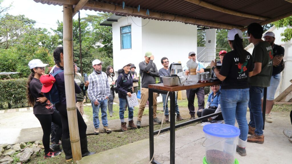 Participantes reciben una demostración de preparación de café durante la jornada