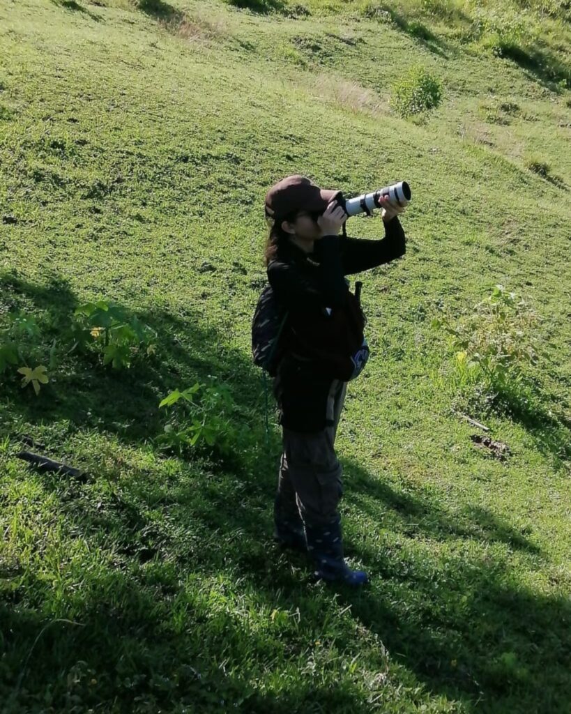 Participante fotografía aves con un teleobjetivo en una ladera