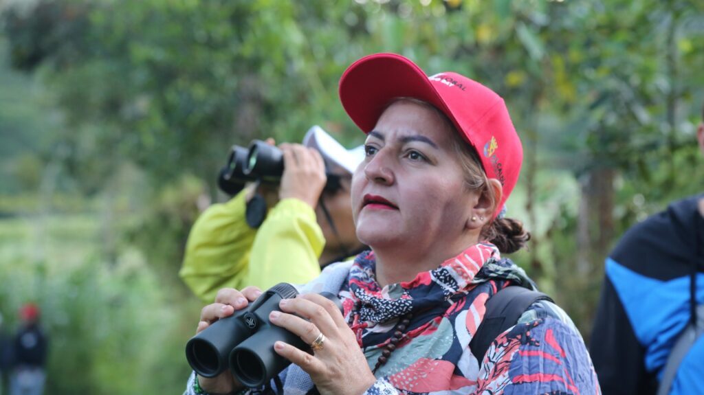 Participante sostiene binoculares durante el recorrido de observación de aves