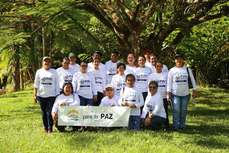 Integrantes del PAI Miel posan con el pendón del PDPMC